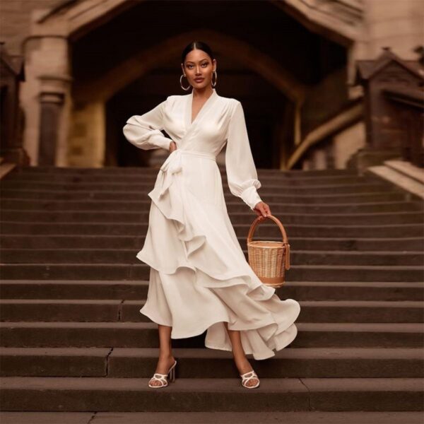 Elegant white satin long-sleeve V-neck dress with a belted waist and ruffle hem, ideal for formal occasions.