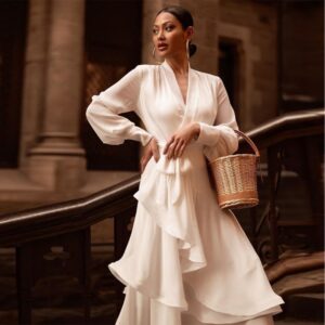 Elegant white satin long-sleeve V-neck dress with a belted waist and ruffle hem, ideal for formal occasions.