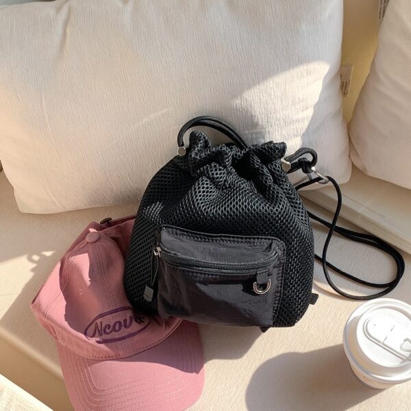 Trendy small mesh drawstring bucket bag with adjustable shoulder strap and front zip pocket, perfect for casual wear.