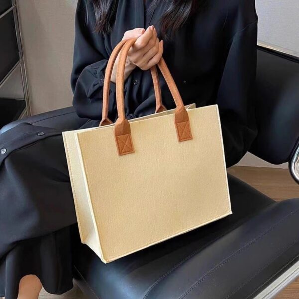 Stylish large capacity felt tote bag in beige, medium gray, and orange with sturdy handles, perfect for shopping and daily use.