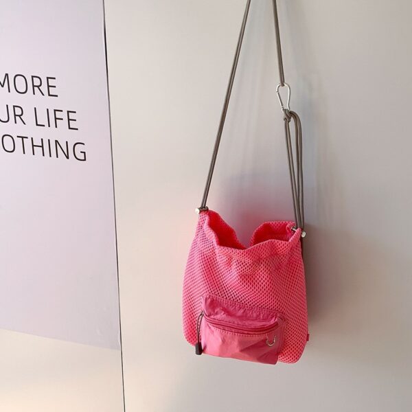 Trendy small mesh drawstring bucket bag with adjustable shoulder strap and front zip pocket, perfect for casual wear.