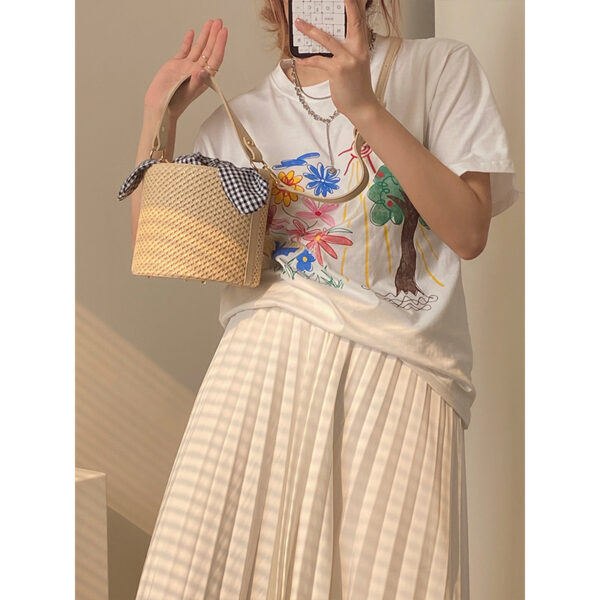 Women’s stylish bucket straw bag with a gingham fabric bow, perfect for summer fashion and casual outings.