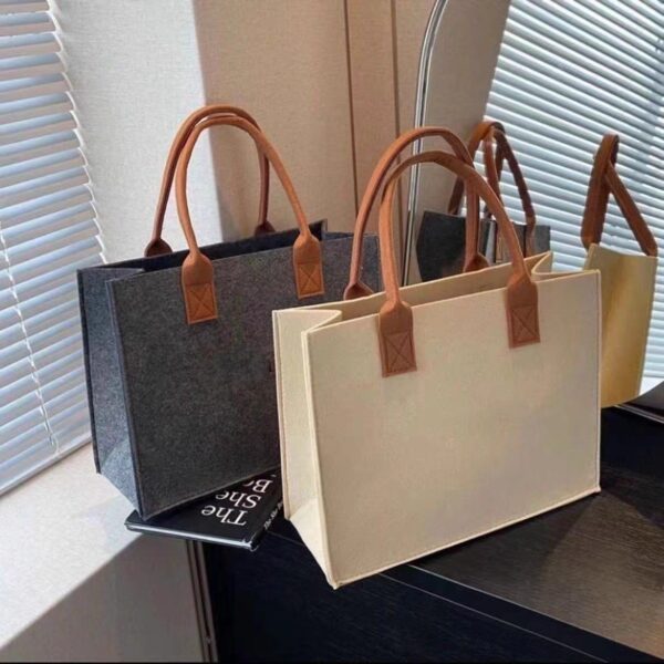 Stylish large capacity felt tote bag in beige, medium gray, and orange with sturdy handles, perfect for shopping and daily use.