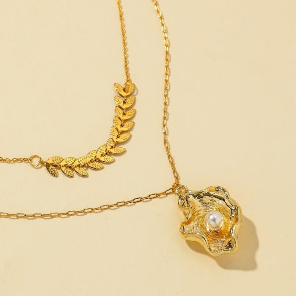 Gold-plated layered necklace with a geometric leaf chain and a shell pendant with pearl accent for a stylish and elegant look.
