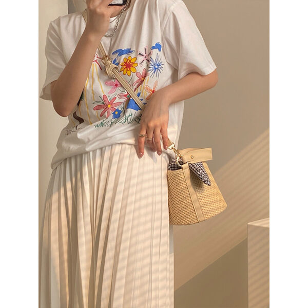 Women’s stylish bucket straw bag with a gingham fabric bow, perfect for summer fashion and casual outings.